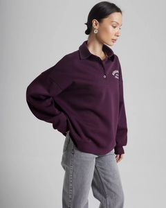 Detail of deep purple lapel sweatshirt with white letter print and loose fit texture