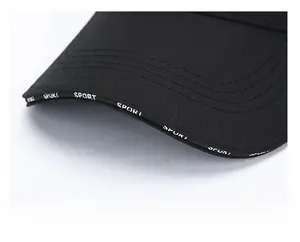 Detail of black baseball cap brim with reinforced stitching and white SPORT print