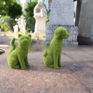 Detail of green flocked sitting dog and cat statues for outdoor garden decoration