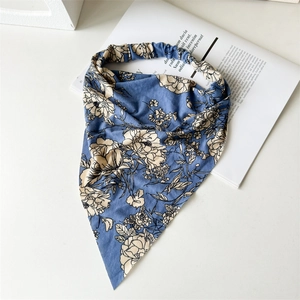 Close-up of blue floral triangle headscarf with elastic band on a white background