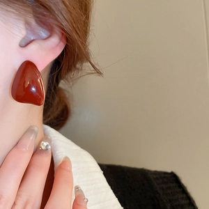 Close-up of vintage deep red teardrop earrings showing the glossy oil drip finish