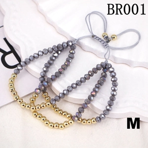 Detail of three adjustable braided bracelets with grey crystal beads and gold metal accents