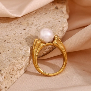 Detailed view of 18K gold plated ring with white pearl on a natural stone base