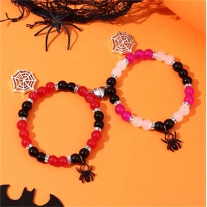 Detailed Halloween magnetic heart bracelets with spider charms on festive orange background