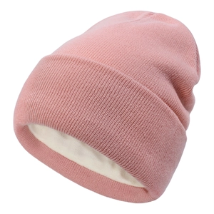 Detail of pink knitted beanie featuring warm white fleece lining and ribbed texture