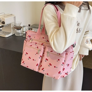 Lifestyle shot of pink cherry print tote bag showing casual shoulder bag style and capacity