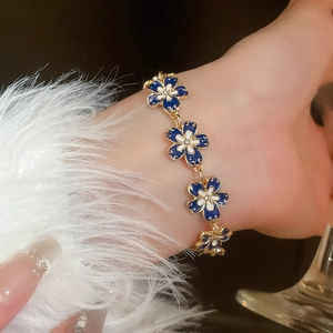 Detailed shot of a French vintage floral bracelet with gold chain on a soft sleeve