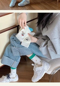 Close-up of women's cotton mid-calf socks featuring cute embroidered dog and panda patterns