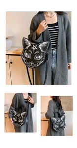 Detail view of a black cat face crossbody bag with star print and adjustable strap
