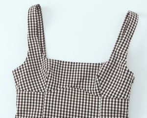 Detailed view of the square neckline and side zipper on brown checkered top