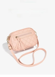 Detailed close-up of pink quilted faux leather crossbody bag with metallic chain and zipper