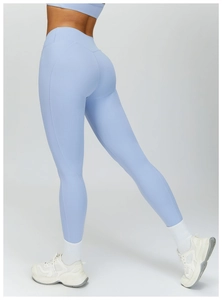 Detail of high-waisted light blue yoga pants with booty-lifting seams and matte finish