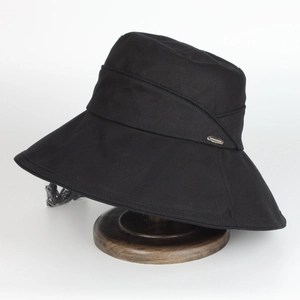 Détail d'un chapeau de soleil noir à large bord avec cordon coupe-vent et logo en métal