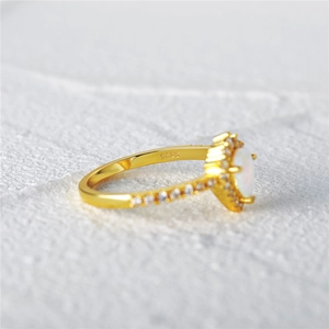 Close-up of gold-plated 925 silver ring with oval opal and sparkling zirconia accents