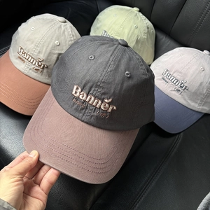 Detailed close-up of embroidered letters on multi-color cotton twill baseball caps