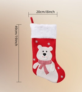 Detail view of a red velvet Christmas stocking with polar bear embroidery and dimensions