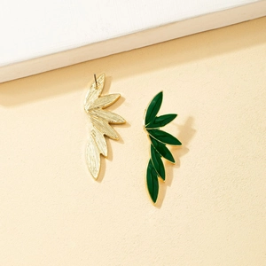Macro detail showing green enamel leaf earrings with realistic golden vein texture