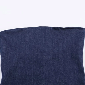 Vue détaillée de la texture du denim bleu foncé et des coutures d'une robe asymétrique