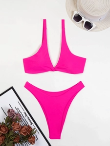 Dettaglio del bikini rosa vivace a due pezzi con parte superiore a nodo e taglio alto