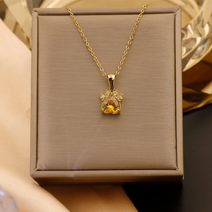 Détail du pendentif patte de chat en or 18K avec zircon cœur jaune et pierres blanches