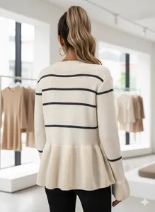 Detail of knit peplum hem on creamy white long sleeve sweater with black horizontal stripes