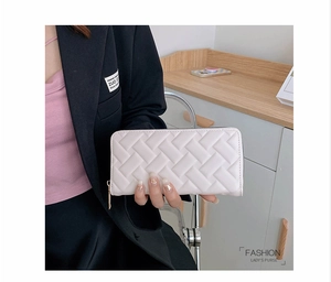 Detailed close-up of cream woven leather wallet with premium gold zipper hardware