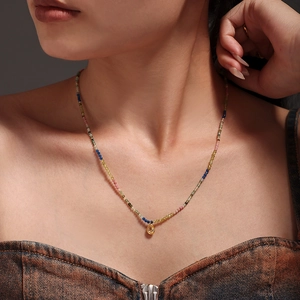 Collier de perles en pierres naturelles avec pendentif goutte dorée sur un mannequin