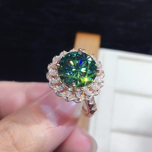Macro detail of round green gemstone ring with floral diamond halo and rose gold band