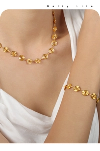 Detailed view of geometric spiral disc necklace and bracelet set in gold finish