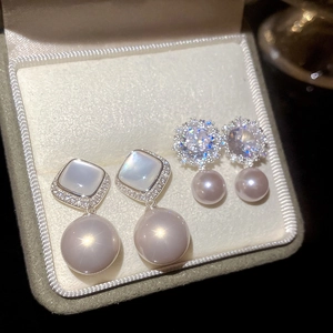 Detail of silver flower stud earrings with zircon crystals and pink pearls in a box