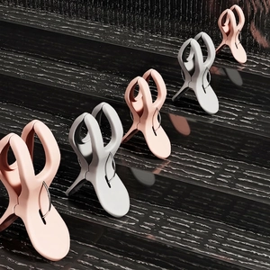 Windproof large plastic quilt clips in pink and gray on a textured drop surface