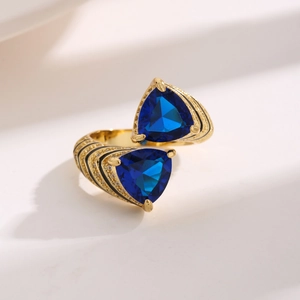 Luxurious gold ring with staggered blue triangle zircons and black enamel accents