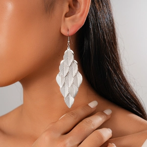 Detailed view of silver layered leaf tassel earrings with metallic wrinkled texture