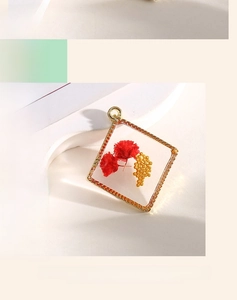 Close-up of geometric square pendant featuring red dried flowers in clear resin