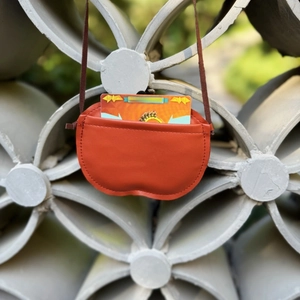 Detail view of orange lychee texture mini crossbody bag showing internal card capacity