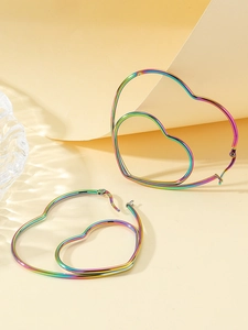Gros plan sur les boucles d'oreilles en cœur d'acier inoxydable aux reflets arc-en-ciel