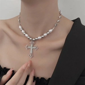 Detail of silver cross pendant necklace with white pearls and sparkling rhinestones