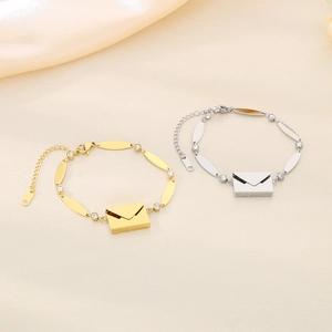Close-up of envelope charms on gold and silver polished bracelets with crystal accents