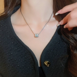 Close-up of model wearing silver multilayer zircon cylinder pendant necklace on collarbone