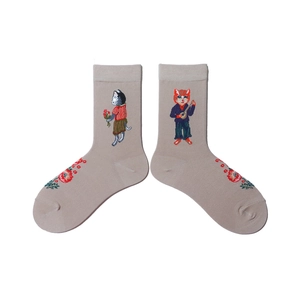 Close-up of animal embroidery featuring cartoon cats on cotton crew socks in light brown