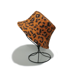 Detailed side view of a stylish leopard print bucket hat on a minimalist stand