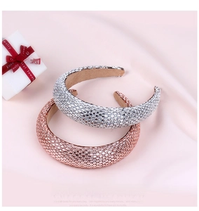 Detailed shot of silver and rose gold rhinestone padded headbands on pink silk fabric