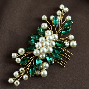 Detailed macro view of handmade gold bridal hair comb with green crystals and white pearls