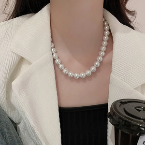 Close-up of elegant white pearl necklace on model's neck showcasing lustrous finish