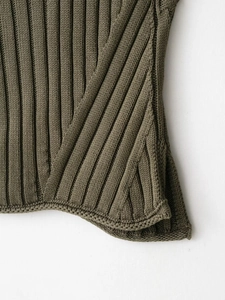 Detailed macro view of olive green ribbed knit hem on sleeveless high neck sweater