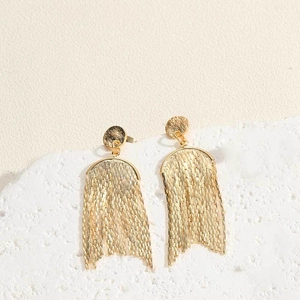 Detailed macro view of 14K gold plated tassel drop earrings with cascading metal chains