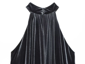Dettaglio dell'abito halter in velluto nero con pieghe eleganti e finitura lucida