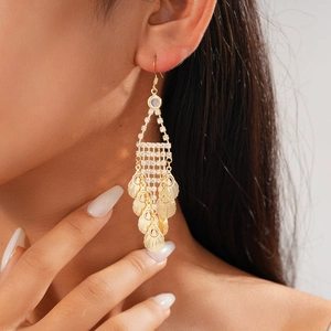 Detail von goldenen Blatt-Fransenohrringen mit Strass an einem Modell für Luxusstil