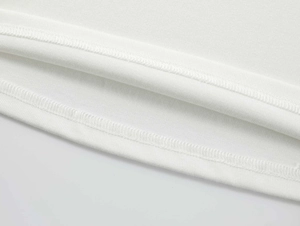 Close-up of the double-needle hem stitching and white modal knit fabric texture