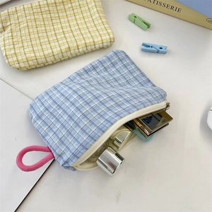 Dettaglio di pochette a quadretti con cerniera e passante rosa nei colori blu e giallo